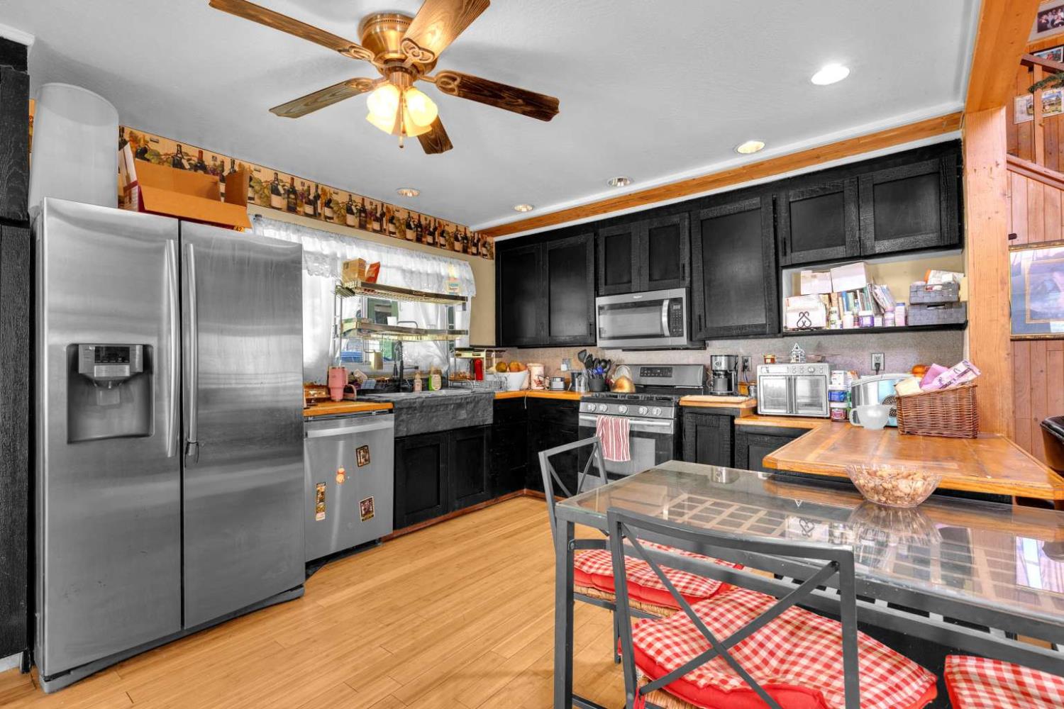 13489 Yorkshire Road Groveland, CA 95321 - Photo 11 of 35 a kitchen with stainless steel appliances granite countertop a refrigerator a sink dishwasher a stove and a dining table with wooden floor