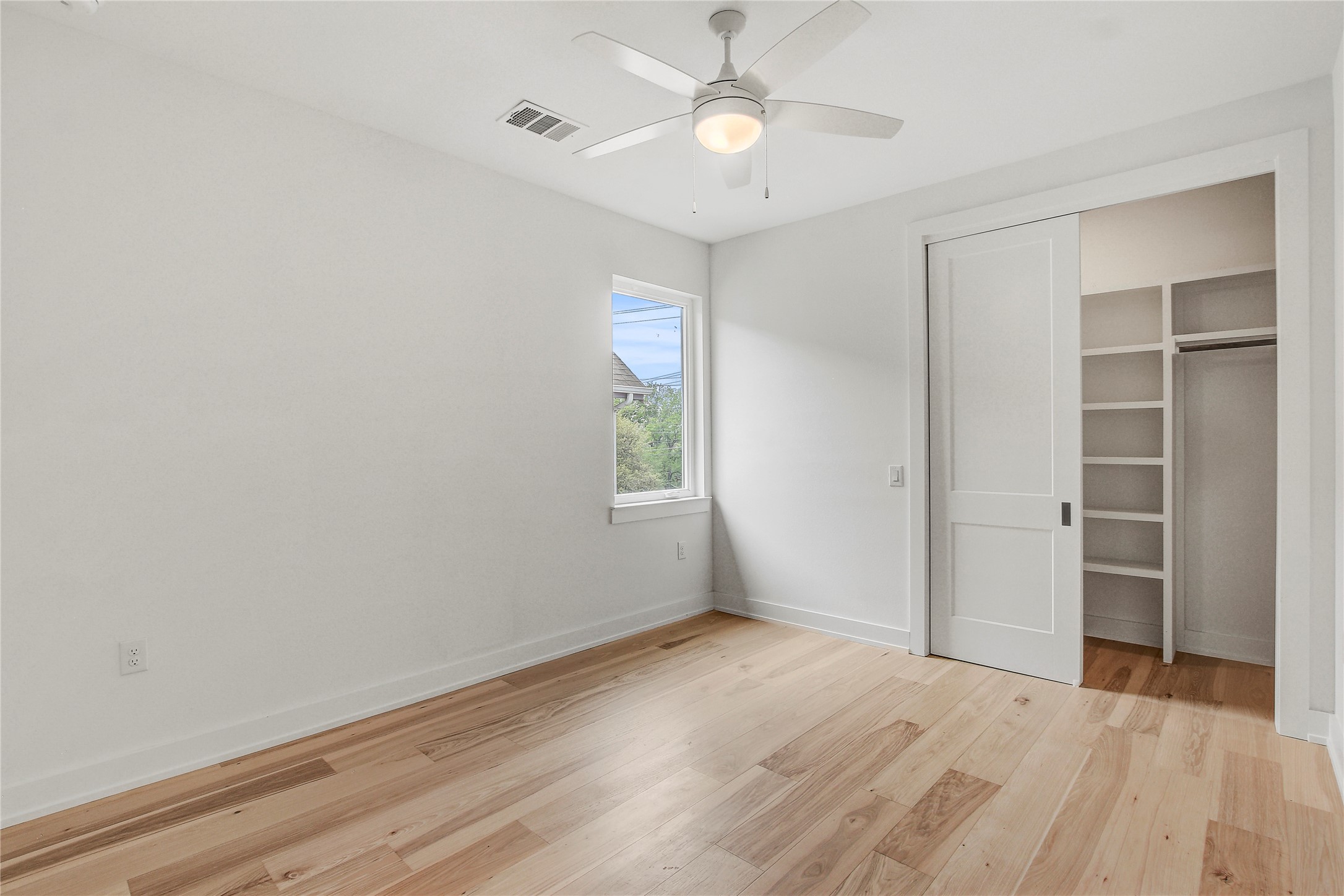 4127 East 12th Street, Unit 2 Austin, TX 78721 - Photo 28 of 28 Unfurnished bedroom featuring light wood-style floors, baseboards, a closet, and ceiling fan