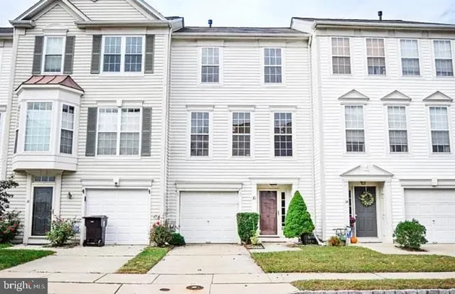 a front view of a building with a garden and plants