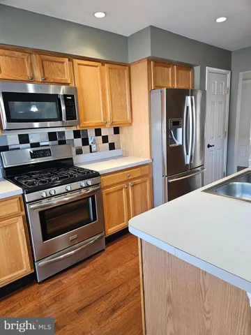 a kitchen with granite countertop a refrigerator stove and microwave