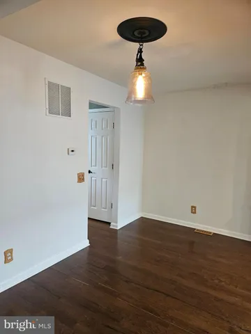 an empty room with wooden floor and ceiling fan