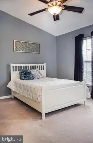 a bedroom with a bed chandelier and a window