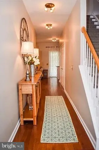 a view of a hallway with a dining hall with wooden floor and a rug