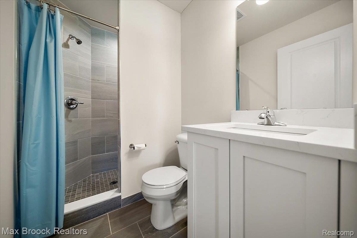 1942 Nottingham Drive Rochester, MI 48307 - Photo 65 of 97 Bathroom with a tiled shower stall featuring a chrome showerhead and control
