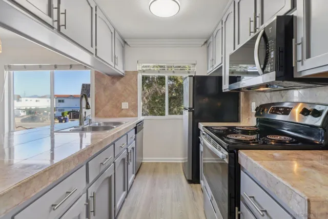 a kitchen with stainless steel appliances granite countertop a stove a sink dishwasher and a refrigerator