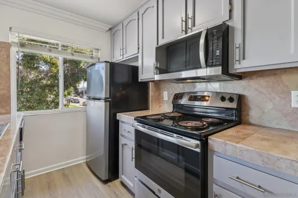 a kitchen with stainless steel appliances granite countertop a stove microwave and refrigerator