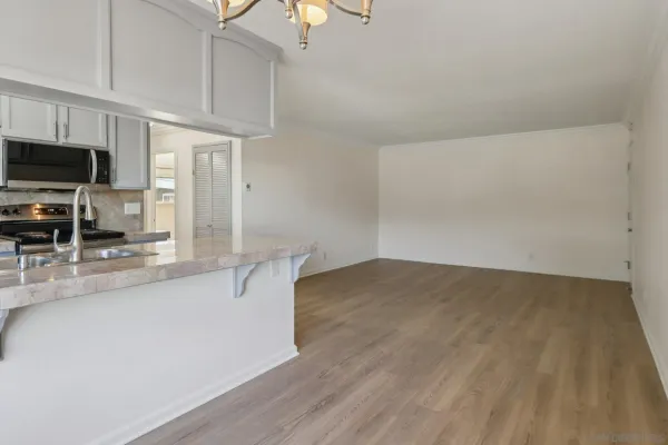 a kitchen with stainless steel appliances a sink cabinets and wooden floor