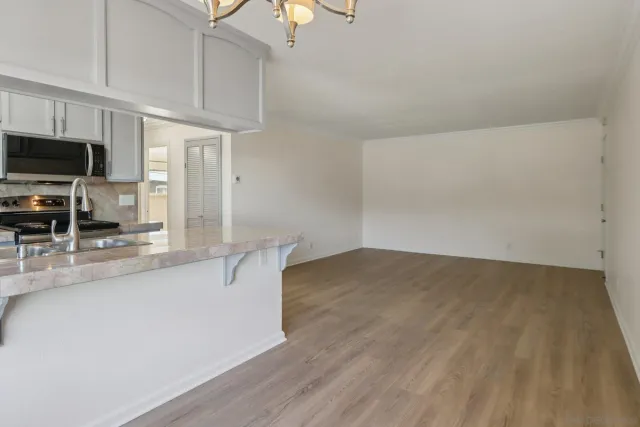 a kitchen with stainless steel appliances a sink cabinets and wooden floor