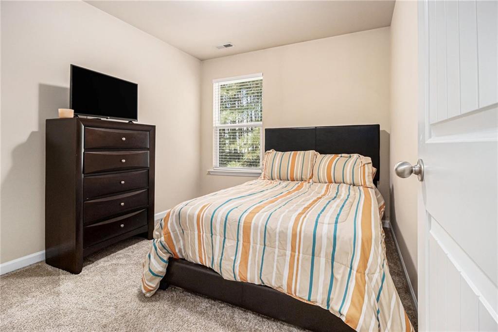 6148 Oakley Road, Unit 23 Union City, GA 30291 - Photo 19 of 26 a bedroom with a bed and a flat tv screen on a dresser