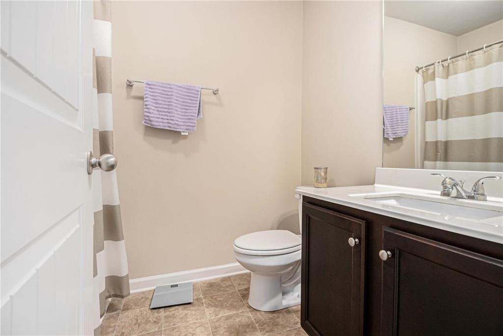 6148 Oakley Road, Unit 23 Union City, GA 30291 - Photo 21 of 26 a bathroom with a granite countertop sink a toilet and a mirror