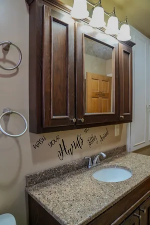 a bathroom with a granite countertop sink and a mirror