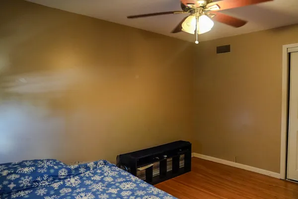 a view of a small space with wooden floor and fan