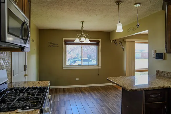 a kitchen with a stove and a wooden floor
