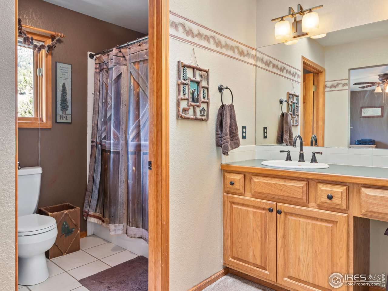 287 Wichita Road Lyons, CO 80540 - Photo 21 of 40 a bathroom with a granite countertop sink toilet and shower