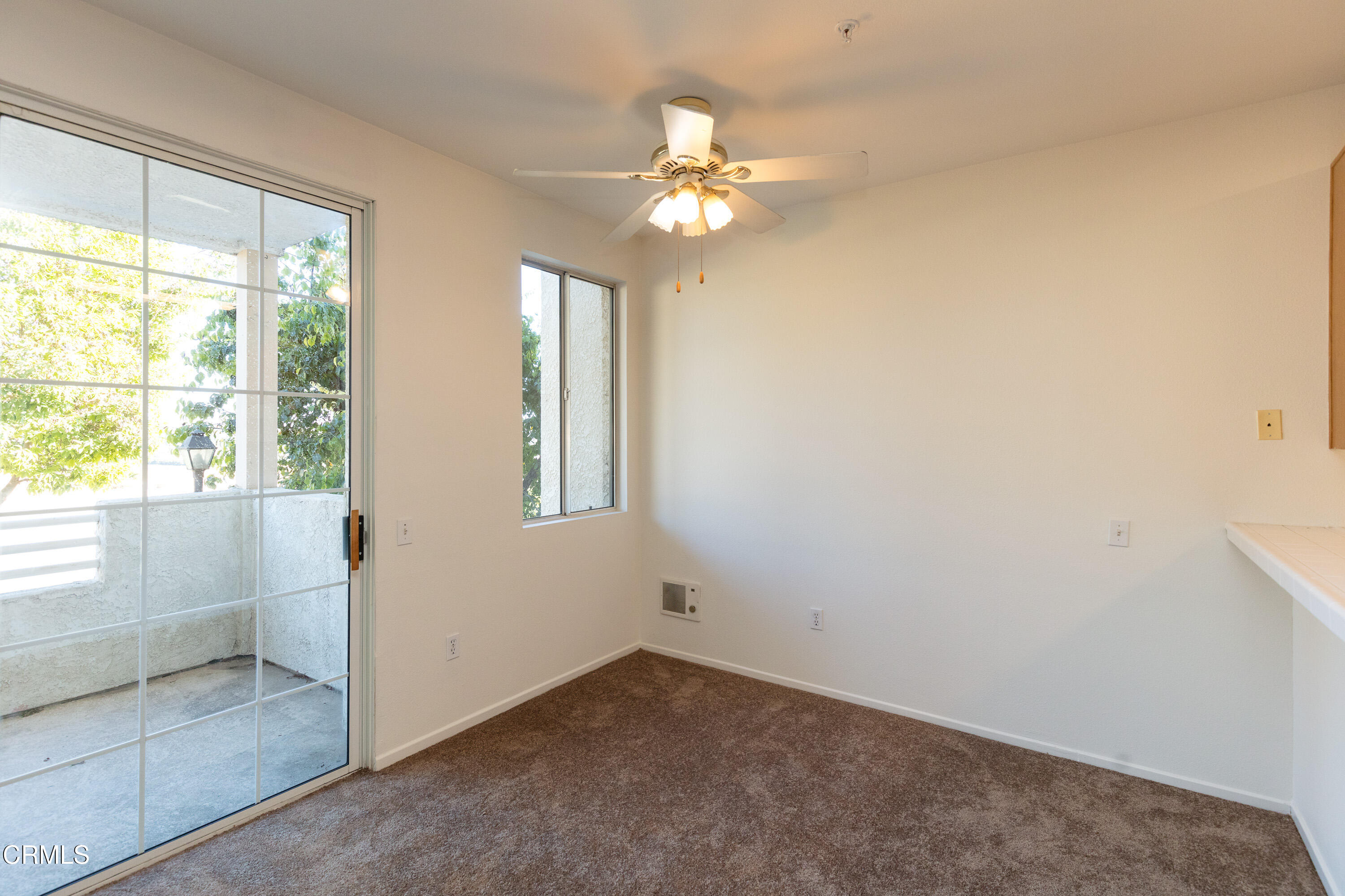 2913 Antonio Drive, Unit 106 Camarillo, CA 93010 - Photo 6 of 14 an empty room with windows and chandelier fan