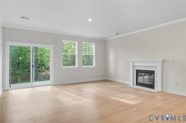 a view of an empty room with a window and a fireplace