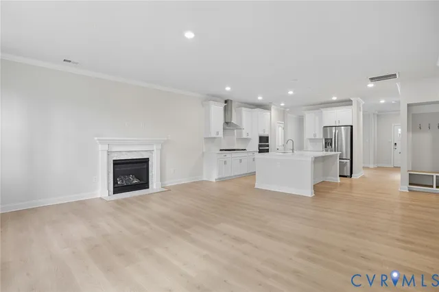 a view of kitchen with kitchen island a sink wooden floor and a refrigerator