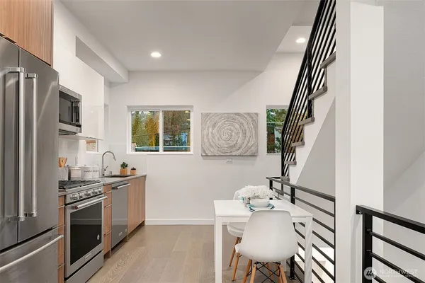 a kitchen with stainless steel appliances granite countertop a sink and a refrigerator