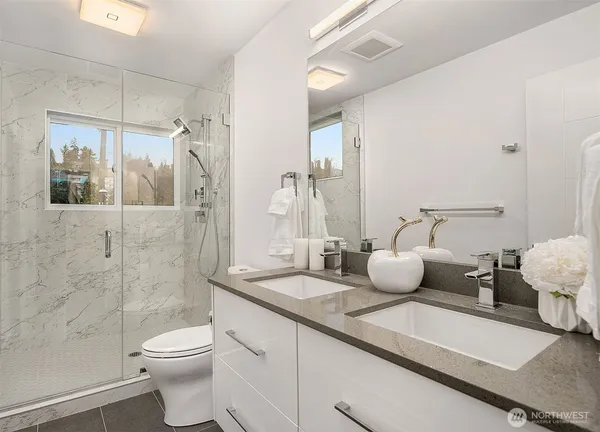 a bathroom with a granite countertop sink mirror and toilet
