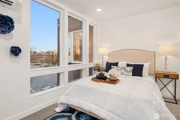 a bedroom with a bed and a large window