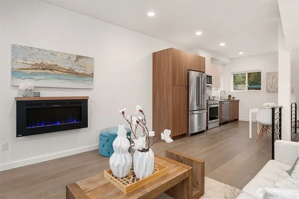 a living room with furniture a kitchen and a fireplace