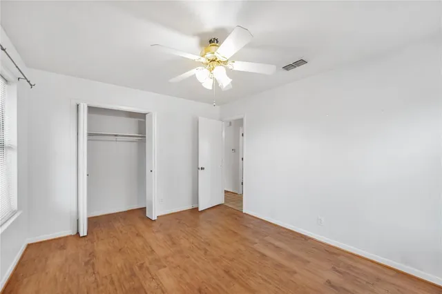 a view of a bedroom with a chandelier fan and a window