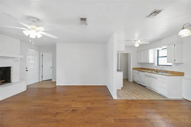 a view of a kitchen with a sink a refrigerator and a fireplace