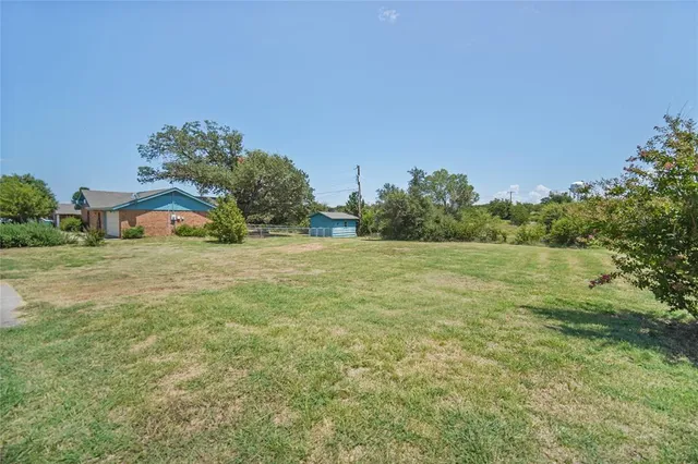 a yellow building in the middle of a yard