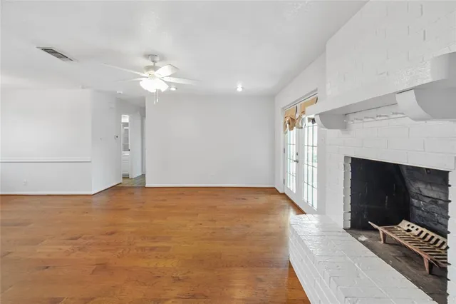 a view of an empty room with a fireplace and a fan