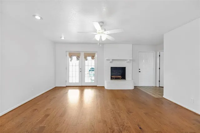 a view of an empty room with a window and a kitchen