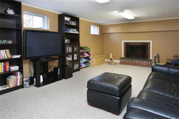 27 Haven Road Wellesley, MA 02481 - Photo 8 of 10 a living room with furniture a bookshelf and a flat screen tv