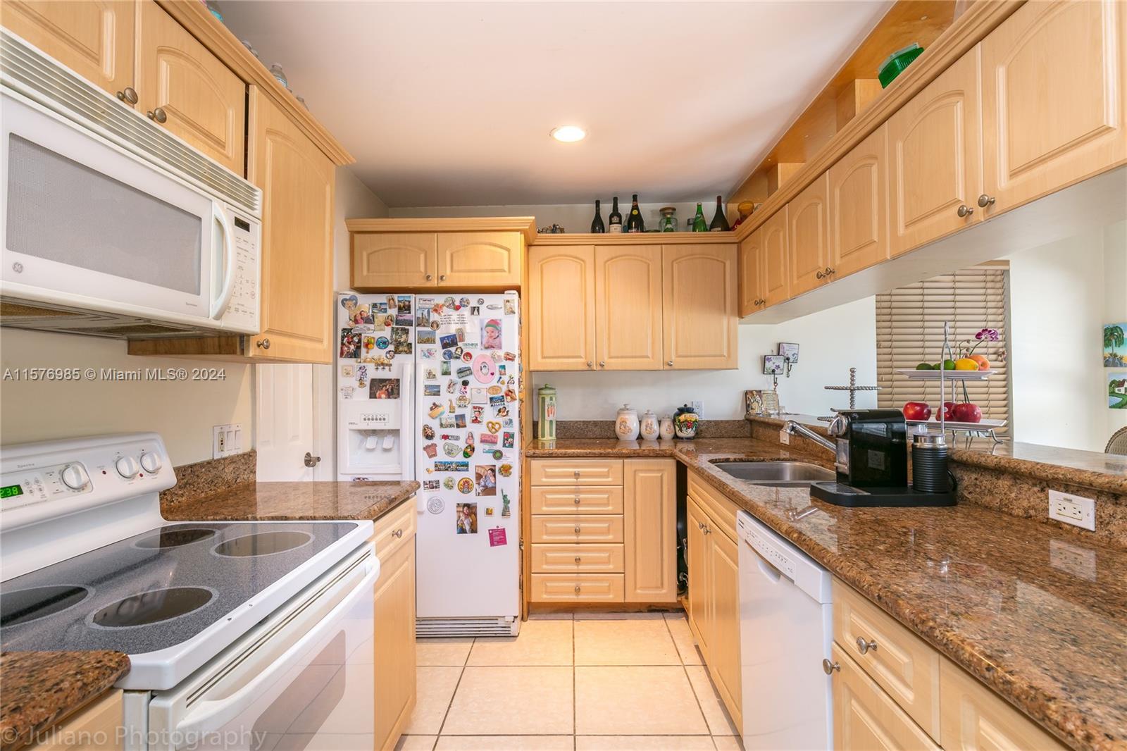 444 Fernwood Road, Unit 444 Key Biscayne, FL 33149 - Photo 16 of 28 a kitchen with kitchen island granite countertop a sink stove and cabinets