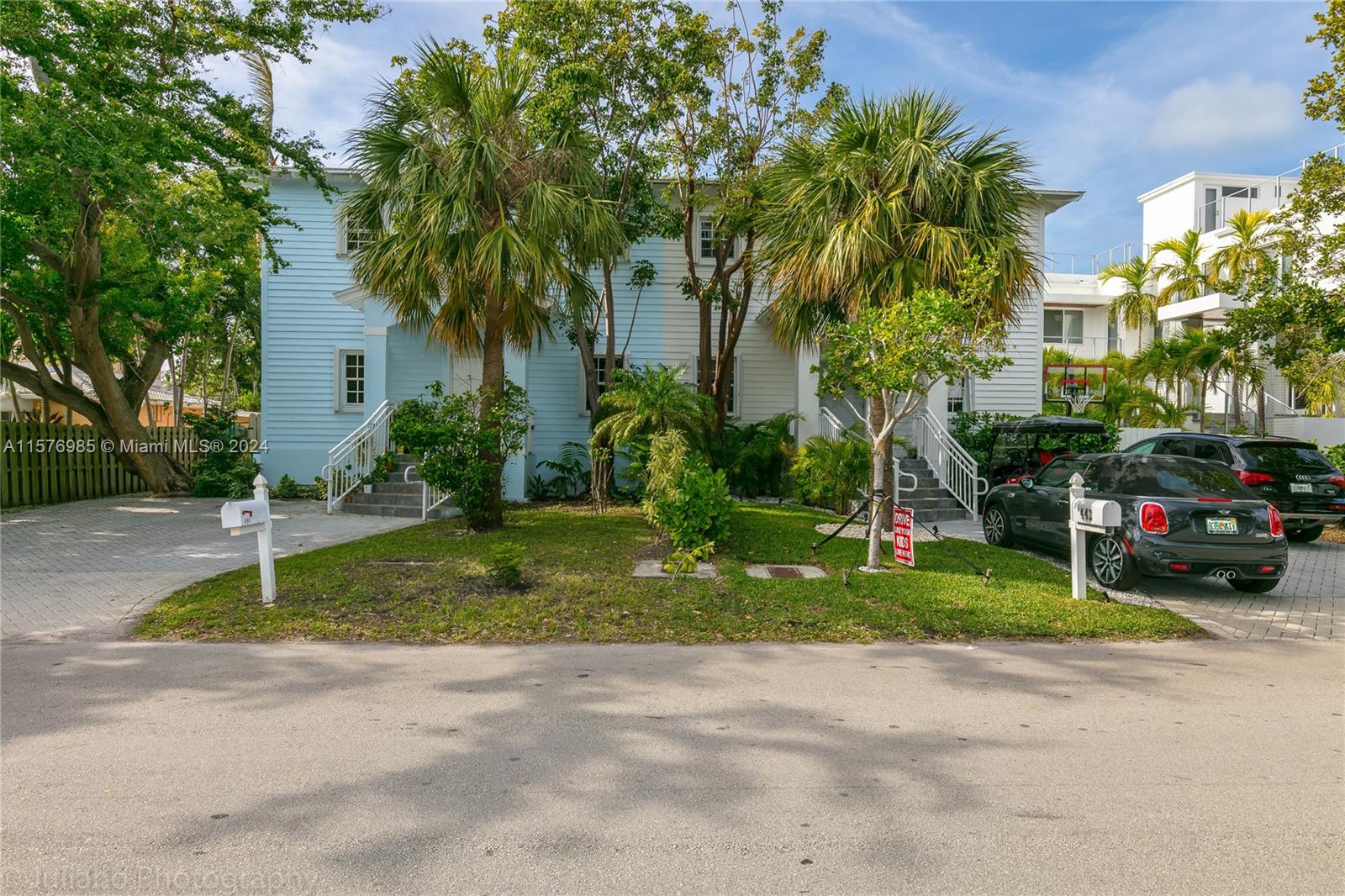 444 Fernwood Road, Unit 444 Key Biscayne, FL 33149 - Photo 2 of 28 a view of a house with a yard and large trees