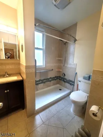 a bathroom with a granite countertop toilet sink and mirror