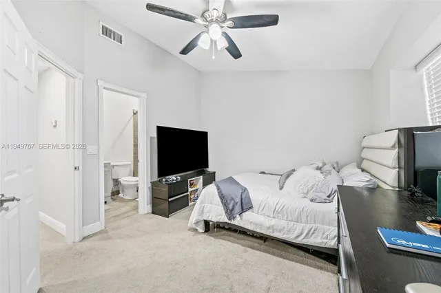 a bedroom with a bed and a flat tv screen on the wall