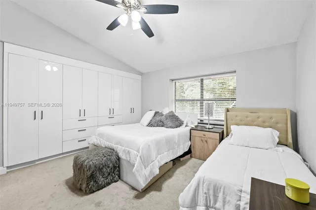 a spacious bedroom with two beds and chandelier