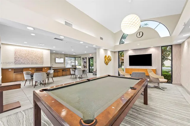 a living room with stainless steel appliances furniture and a flat screen tv