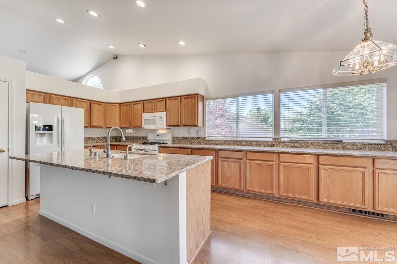502 Silversmith Place Reno, NV 89511 - Photo 13 of 37 a large kitchen with granite countertop a large window and white stainless steel appliances