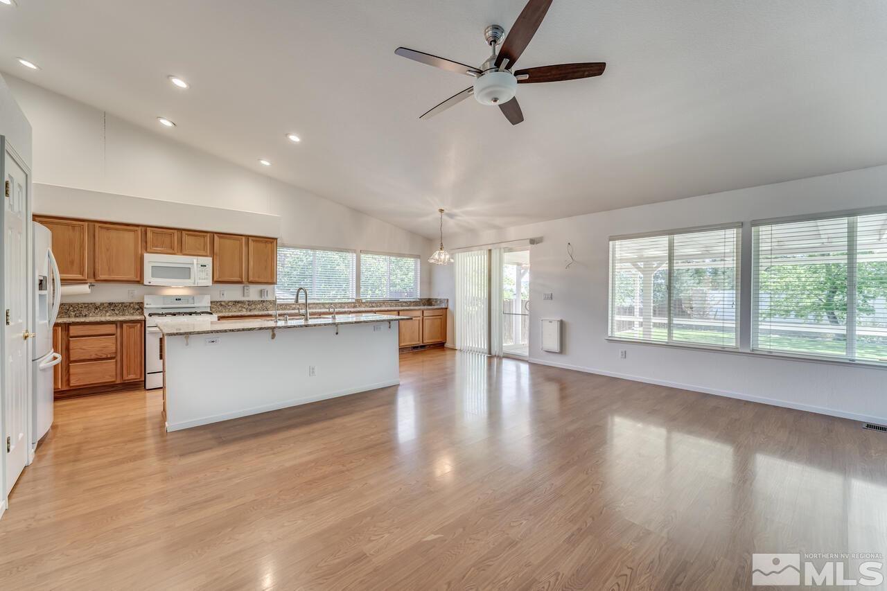 502 Silversmith Place Reno, NV 89511 - Photo 8 of 37 a large kitchen with stainless steel appliances granite countertop a stove top oven a chimney cabinets and wooden floor