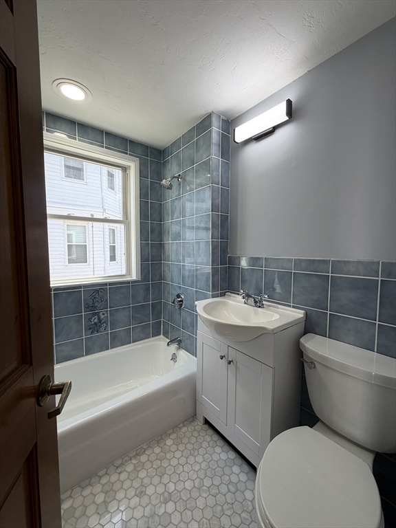 117 Merrymount Road, Unit 1 Quincy, MA 02169 - Photo 9 of 12 a bathroom with a sink mirror bathtub and toilet