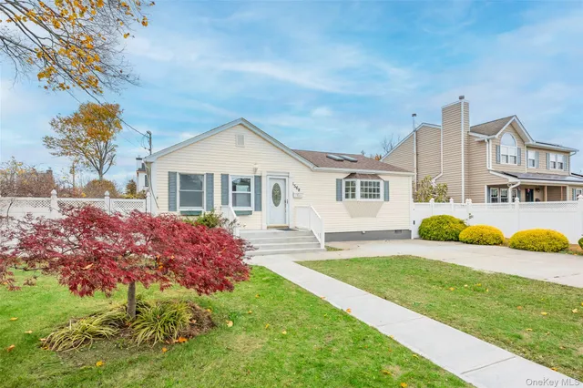 a front view of a house with a garden and trees