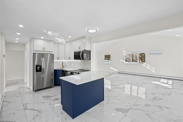 a large white kitchen with a refrigerator a sink and a stove