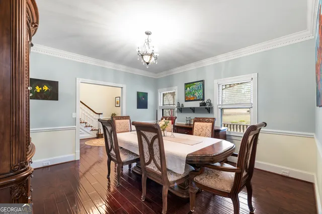 a dining room with furniture a chandelier and wooden floor
