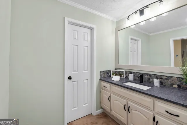 a large white room with a large window and a potted plant