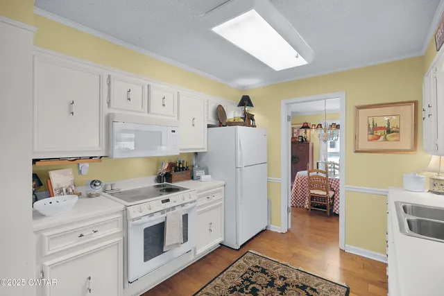a kitchen with white cabinets and white appliances