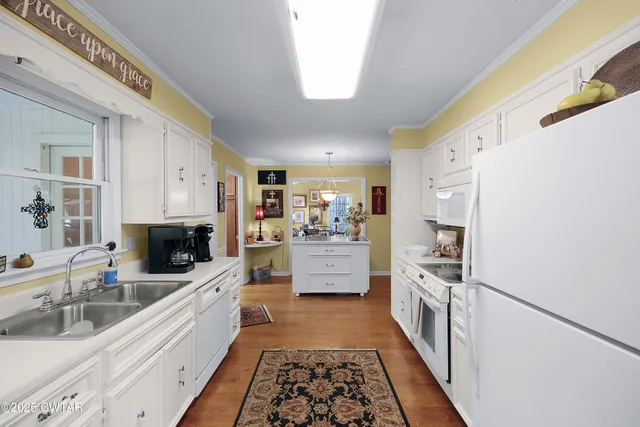 a large white kitchen with stainless steel appliances