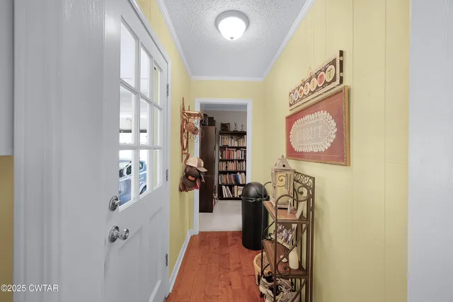 a hallway with painting on the wall and a large mirror