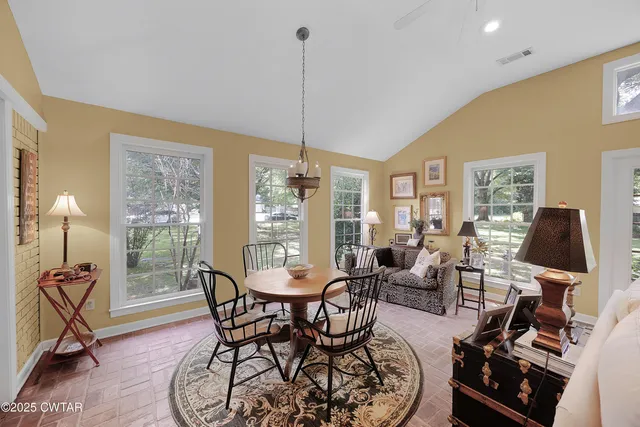 a living room with furniture a fireplace and a chandelier