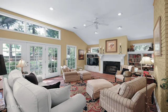a living room with furniture a fireplace and a large window