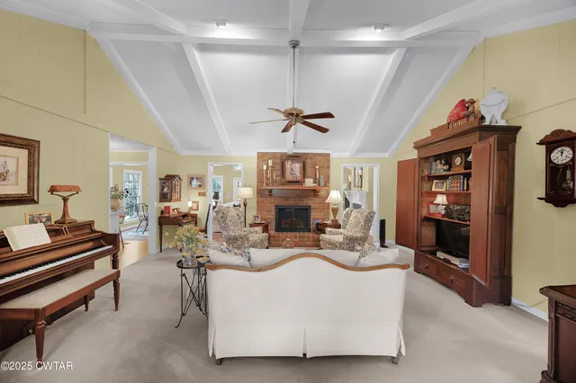 a living room with fireplace furniture and a chandelier